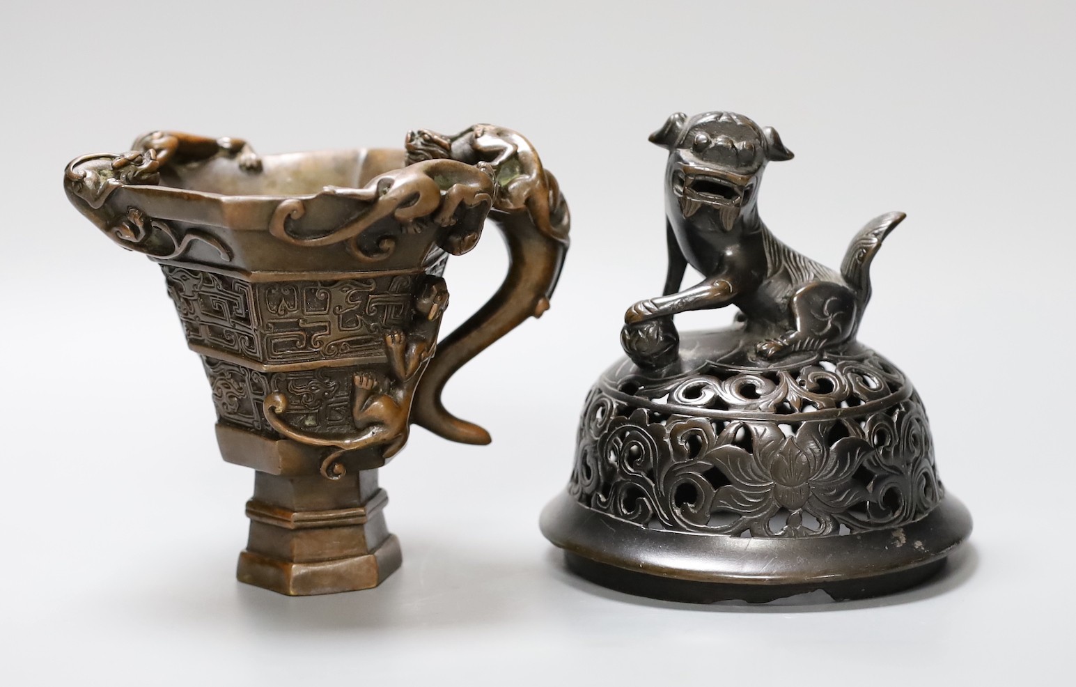 A Chinese bronze handled libation cup, together and a bronze cover with pierced decoration and seated dog, tallest 12cm